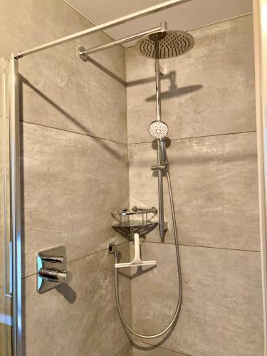a shower with a shower head in a bathroom at Ammerseeidylle im Herzen von Dießen in Dießen am Ammersee