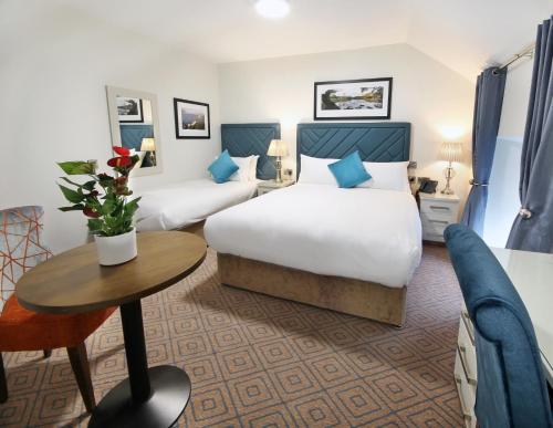 Habitación de hotel con 2 camas y mesa en The Bailie en Cavan