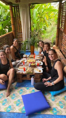 a group of people sitting around a table with food at Casa Encuentro Ecolodge, Outdoor Gym and Yoga in Guatapé