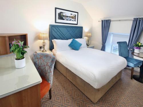 een hotelkamer met een groot bed en een bureau bij The Bailie in Cavan
