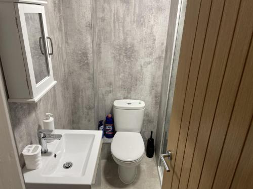 Un baño con un inodoro blanco y un lavabo. en TAIGH CATHIE, 67 Alma Road, en Fort William