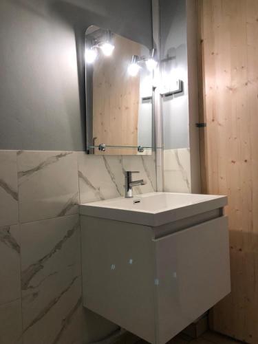 une salle de bain blanche avec un lavabo et un miroir dans l'établissement SAINT LAZARE, à Manosque