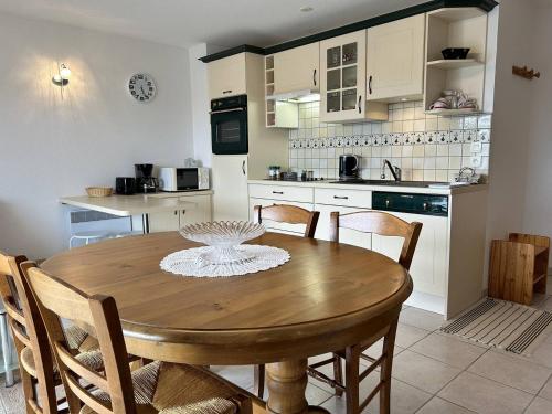- une cuisine avec une table et des chaises en bois dans l'établissement 516 - Appartement T2, à moins de 300m de la Plage., à Erquy