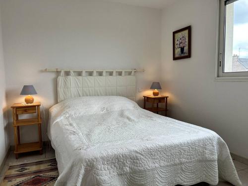 une chambre avec un lit blanc avec deux tables de nuit dans l'établissement 516 - Appartement T2, à moins de 300m de la Plage., à Erquy