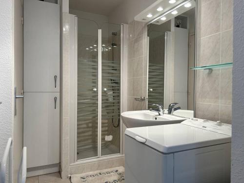 une salle de bain blanche avec une douche et un lavabo dans l'établissement 516 - Appartement T2, à moins de 300m de la Plage., à Erquy