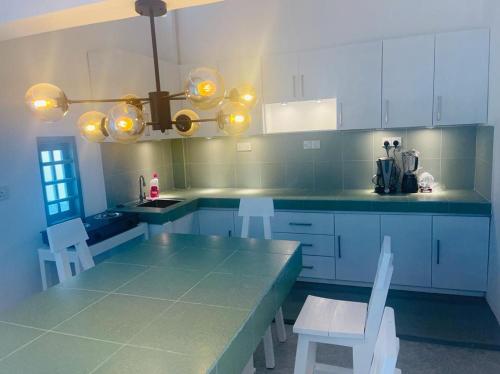 a kitchen with a blue counter and white cabinets at Istana Villa Mirissa in Mirissa