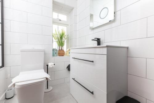 uma casa de banho branca com um WC e um lavatório em GuestReady - Espaço maravilhoso em Brighton e Hove em Brighton & Hove