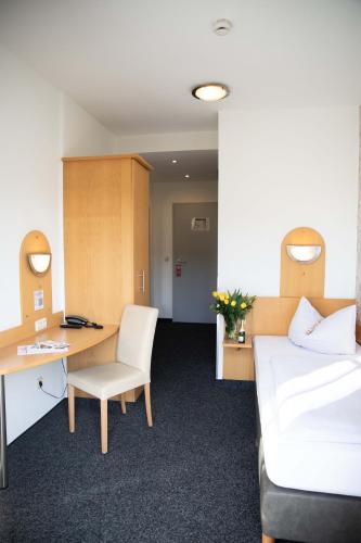 a room with a bed and a desk and a chair at Hotel Regina in Würzburg