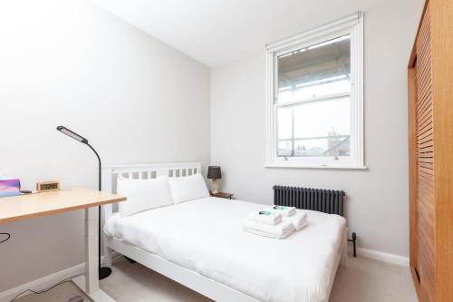 een slaapkamer met een bed, een bureau en een raam bij GuestReady - Espaço maravilhoso em Brighton e Hove in Brighton & Hove