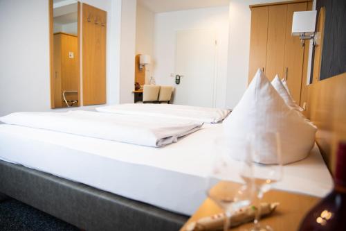 a large white bed in a hotel room at Hotel Regina in Würzburg