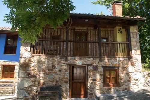 an old stone house with a balcony on top at Casa Jacinta in Bimenes