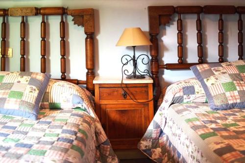 - une chambre avec 2 lits jumeaux et une lampe dans l'établissement Casa Jacinta, à Bimenes