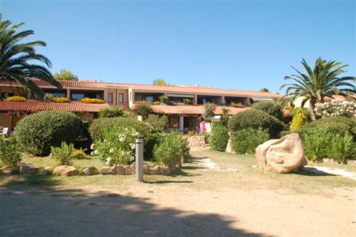 a building with a lot of bushes and trees at Residence Porto Coda Cavallo in San Teodoro