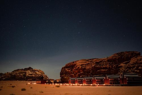 a building on a beach under a starry sky at Wadi Rum Golden Valley in Wadi Rum