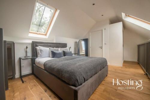1 dormitorio con 1 cama grande y ventana en The Henley Retreat, en Henley on Thames