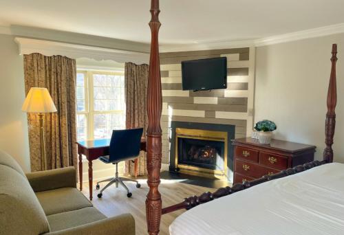 Chadds Ford的住宿－布蘭迪萬河大酒店，一间卧室配有一张床、一张桌子和一个壁炉