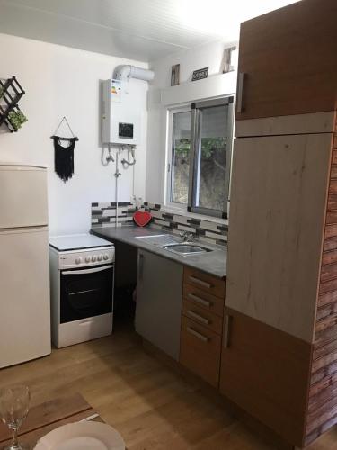 uma pequena cozinha com um lavatório e um fogão em K Hermaioni em Xàtiva