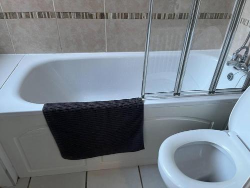 a bathroom with a white bath tub next to a toilet at Lovely 2-Bed House in Liverpool in Liverpool