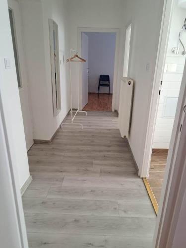 a hallway with white walls and a wooden floor at Tarcal Apartman in Tarcal