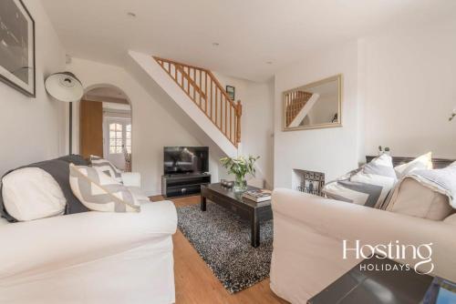 a living room with a white couch and a tv at Stunning Character House In The Centre of Henley in Henley on Thames