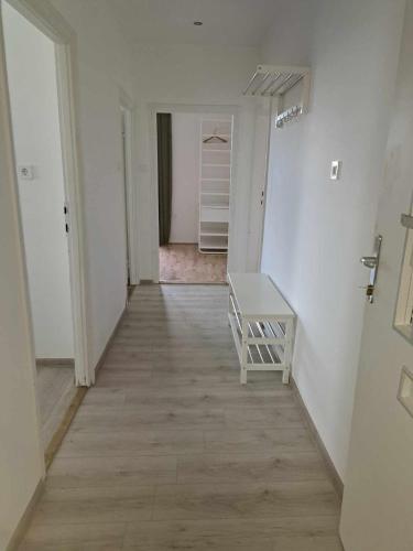 a hallway with white walls and a wooden floor at Tarcal Apartman in Tarcal