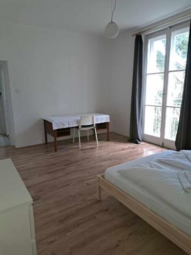 a bedroom with a bed and a table and a window at Tarcal Apartman in Tarcal