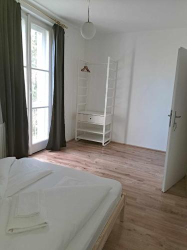 a bedroom with a white bed and a window at Tarcal Apartman in Tarcal