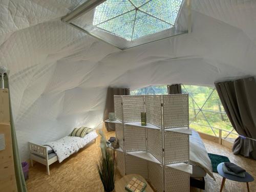 Zimmer mit einem Zelt mit einem Bett und einem Fenster in der Unterkunft Orion - A La Bul'étoile in Loulans-Verchamp