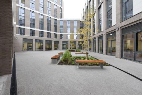 a courtyard with benches in front of a building at For Students Only St Mungo's in Glasgow in Glasgow