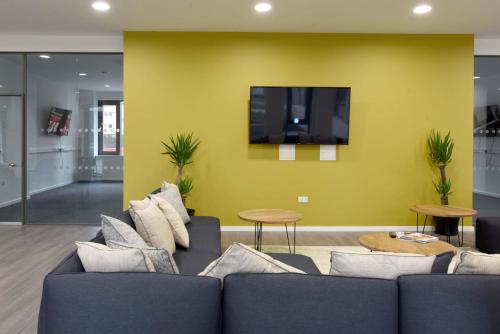 a living room with a couch and a flat screen tv at For Students Only St Mungo's in Glasgow in Glasgow