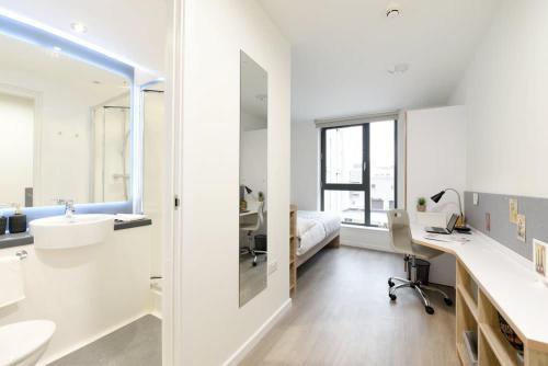 uma casa de banho branca com um lavatório e uma secretária em Modern and Bright Ensuite at St Mungo's in Glasgow for Students Only em Glasgow