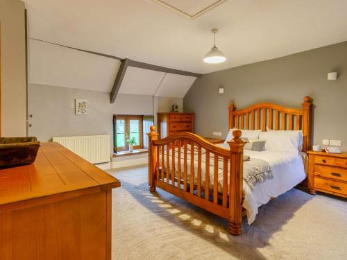 um quarto com uma cama de madeira e uma cómoda em 4 Bed in Abergavenny 88014 em Llanover