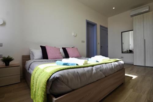 a bedroom with a bed with a yellow blanket on it at Charming and Tranquil House in Għasri