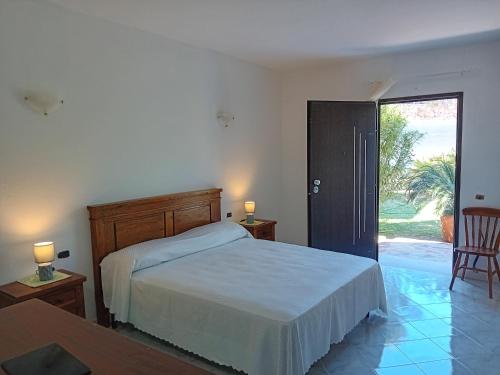 - une chambre avec un lit et une porte donnant sur une terrasse dans l'établissement Bandi House, à San Teodoro