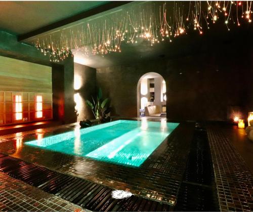 a large swimming pool in a room with chandeliers at Familie & Vriendenwoning met fantastisch uitzicht in Ellezelles