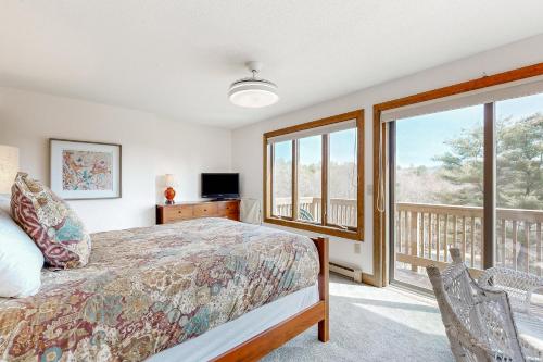 a bedroom with a bed and a balcony at Saltbox 12B in White River Junction