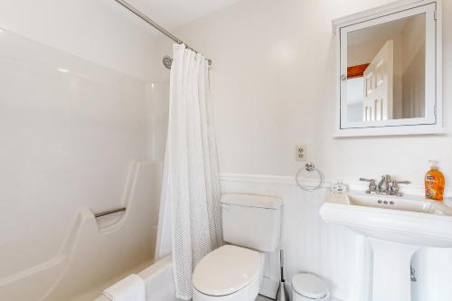 a white bathroom with a toilet and a sink at Saltbox 12B in White River Junction