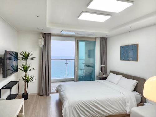 束草市的住宿－Sokcho Summitbay 1402 "Ocean View"，一间卧室设有一张床和一个大窗户