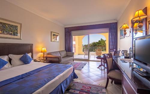 a hotel room with a bed and a television at Caribbean World Resort Soma Bay in Hurghada