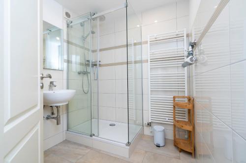 a bathroom with a glass shower and a sink at Panoramic App A14-zehn in Sierksdorf