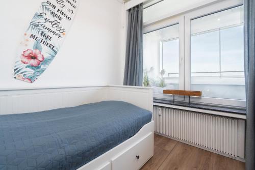 a bedroom with a bed and a window at Panoramic App A14-zehn in Sierksdorf
