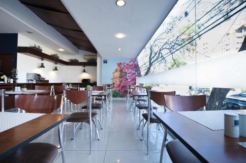 un ristorante con tavoli e sedie e una grande finestra di Hotel LP Santa Cruz Centro a Santa Cruz de la Sierra