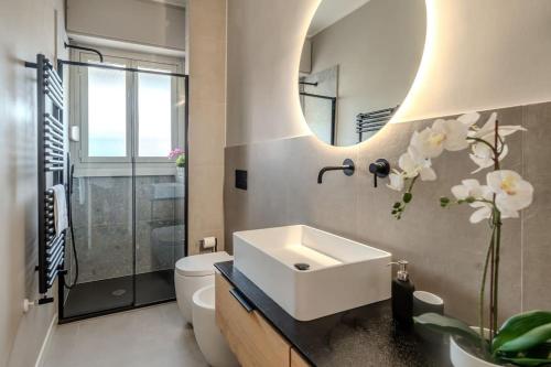 a bathroom with a sink and a toilet and a mirror at Casa Rondò in Sesto San Giovanni