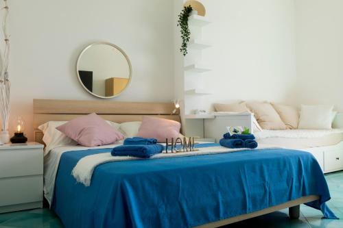 a bedroom with a bed with blue sheets and a mirror at Villa Venere - Amalfi Coast - Private Sea Access in Cetara