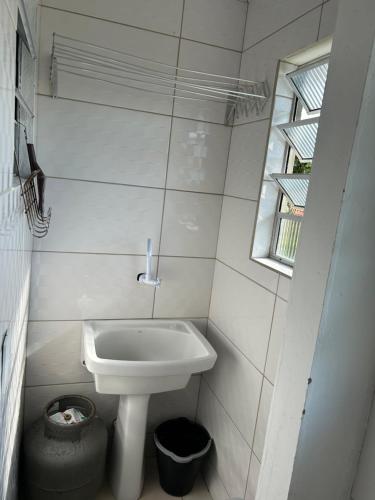 een kleine badkamer met een wastafel en een raam bij Recanto do Sul - Campeche in Florianópolis
