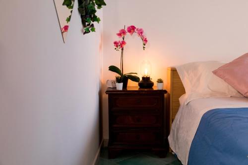 a bedroom with a bed and a dresser with flowers on it at Villa Venere - Amalfi Coast - Private Sea Access in Cetara