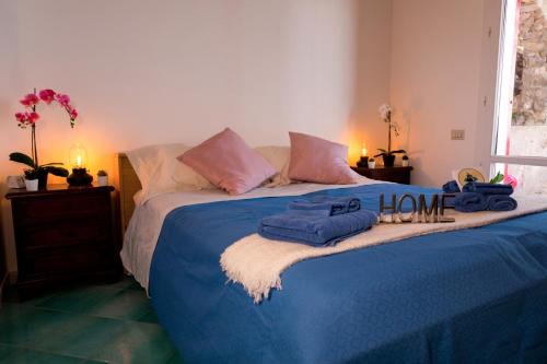 a bedroom with a blue bed with towels on it at Villa Venere - Amalfi Coast - Private Sea Access in Cetara