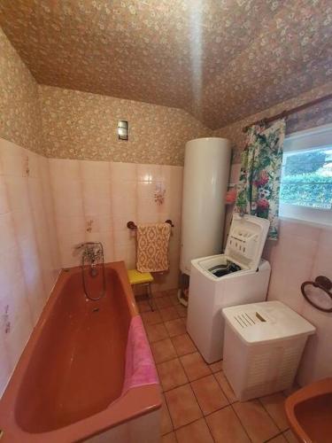 La salle de bains est pourvue d'une baignoire, d'un évier et d'un réfrigérateur. dans l'établissement Villa proche centre-ville - 8182, à Soulac-sur-Mer