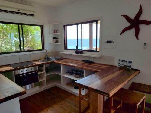 een keuken met een tafel en een groot raam bij 180° Ocean View Dune House in Chefe Imala