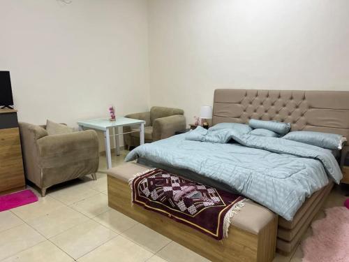 a bedroom with a large bed and a table at شقة بجوار مسجد قباء in Al Madinah